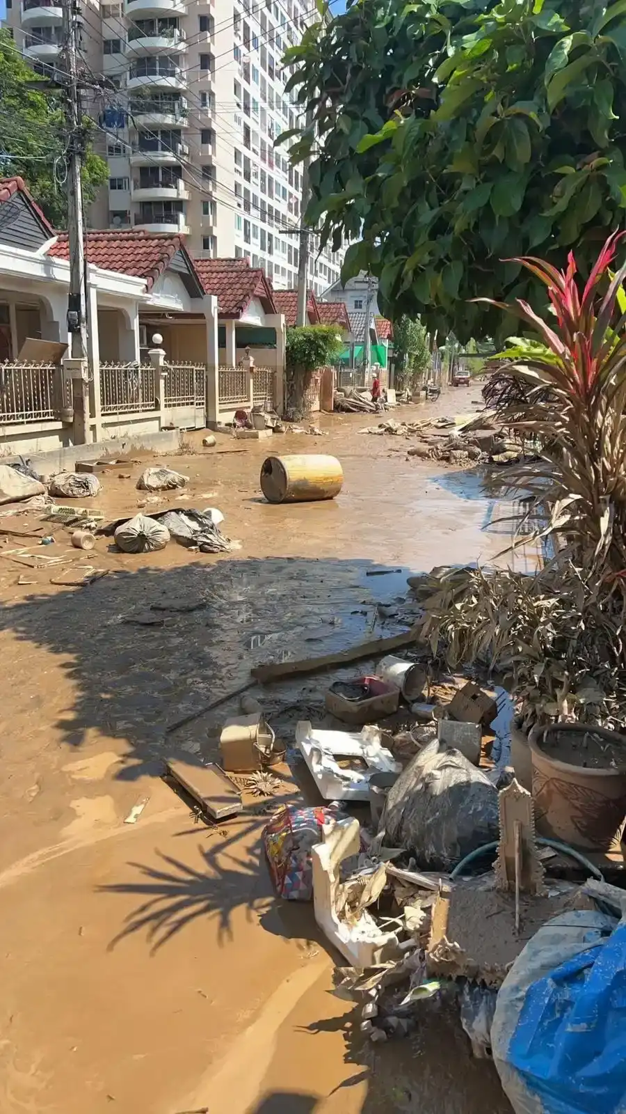 Flood debris and mud-caked furniture piled outside homes near Chang Klan after the water receded