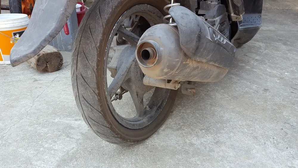 Close-up of a worn motorbike tyre showing damage