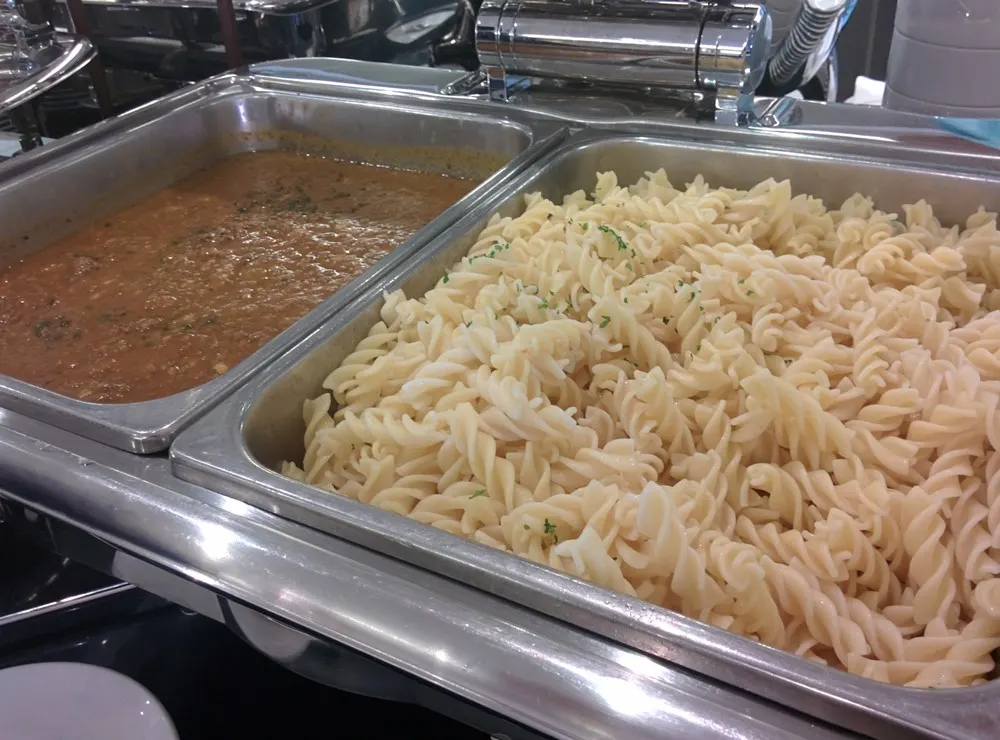 Pasta and curry chafing dishes on the buffet line